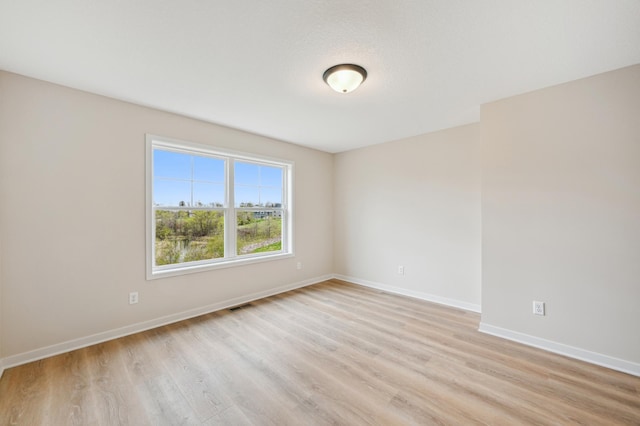 empty room featuring light wood-style flooring and baseboards