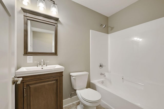 bathroom with vanity, toilet, baseboards, and  shower combination
