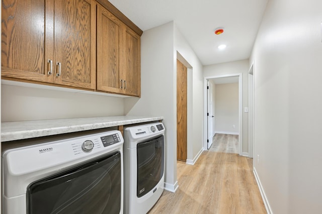 washroom featuring washing machine and dryer, light wood-style floors, cabinet space, baseboards, and recessed lighting
