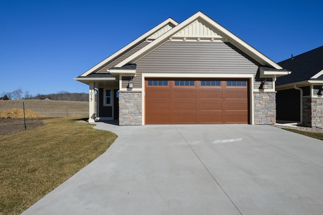 craftsman-style home featuring concrete driveway, a front lawn, stone siding, and board and batten siding