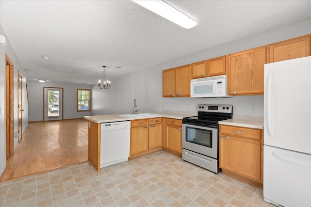 1960 Pika Trl Unit C, River Falls, WI 54022 - kitchen featuring white appliances, a sink, a peninsula, a chandelier, and light countertops