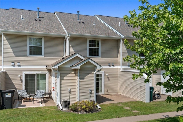 1960 Pika Trl Unit C, River Falls, WI 54022 - rear view of property with a patio area, a lawn, a shingled roof, and cooling unit