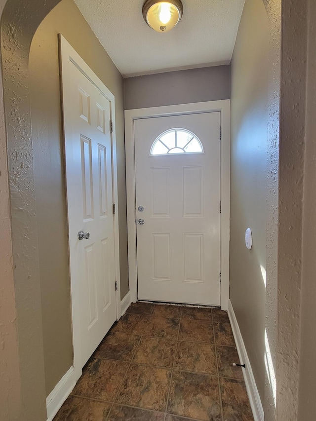 entryway featuring baseboards and stone finish floor