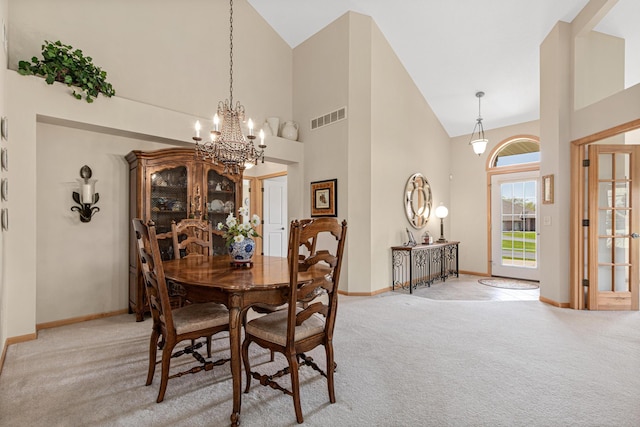 dining room with light carpet, high vaulted ceiling, a chandelier, and baseboards