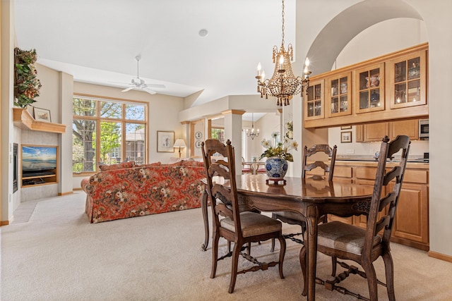 dining space with light carpet, a chandelier, a ceiling fan, and baseboards