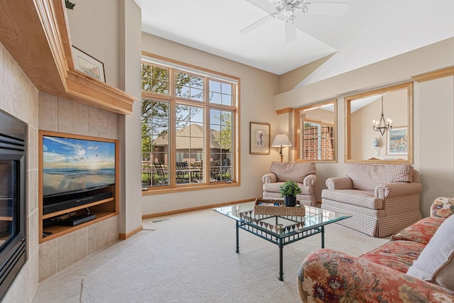 living room with carpet, baseboards, a chandelier, and a ceiling fan