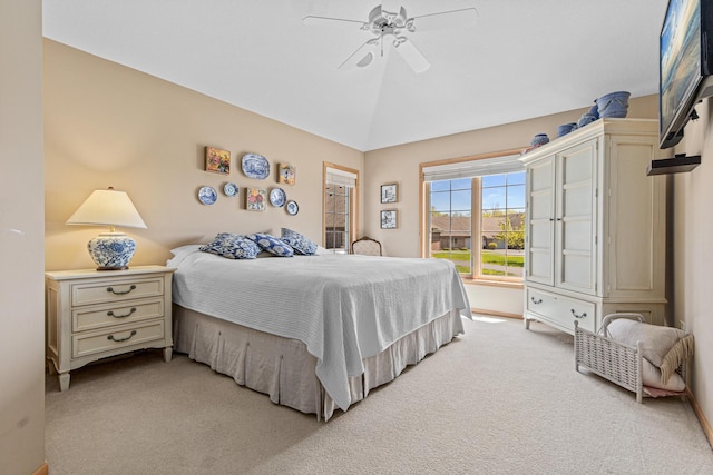 bedroom featuring light colored carpet, vaulted ceiling, baseboards, and a ceiling fan