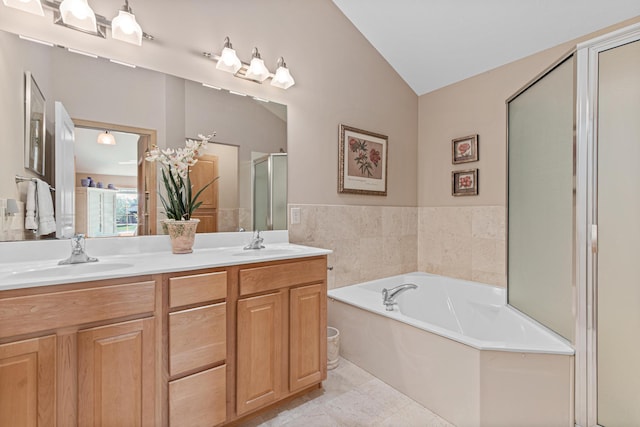 bathroom featuring double vanity, a garden tub, a stall shower, and lofted ceiling