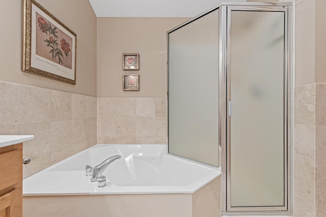 bathroom with vanity, a shower stall, and a garden tub