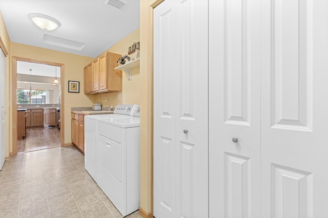 washroom featuring cabinet space, independent washer and dryer, baseboards, and light tile patterned floors