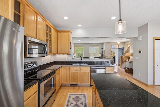 kitchen with recessed lighting, stainless steel appliances, light wood-type flooring, and a sink