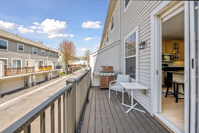 wooden terrace with area for grilling and a residential view