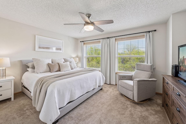 bedroom with light colored carpet, a textured ceiling, and ceiling fan