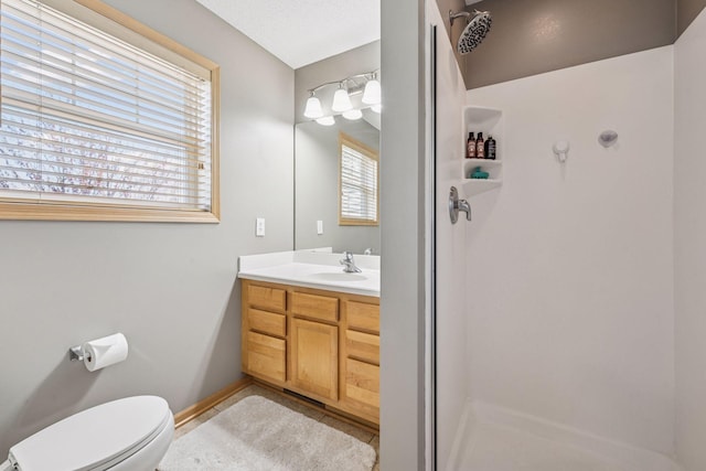 full bath featuring toilet, tile patterned floors, baseboards, walk in shower, and vanity