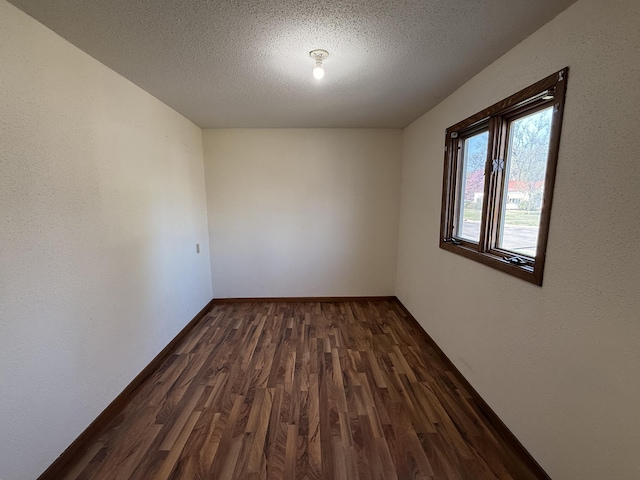321 Western Ave, Madison, MN 56256 - spare room with dark wood-style flooring, a textured ceiling, and baseboards