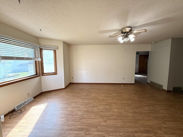 321 Western Ave, Madison, MN 56256 - spare room featuring a textured ceiling, ceiling fan, wood finished floors, and baseboards