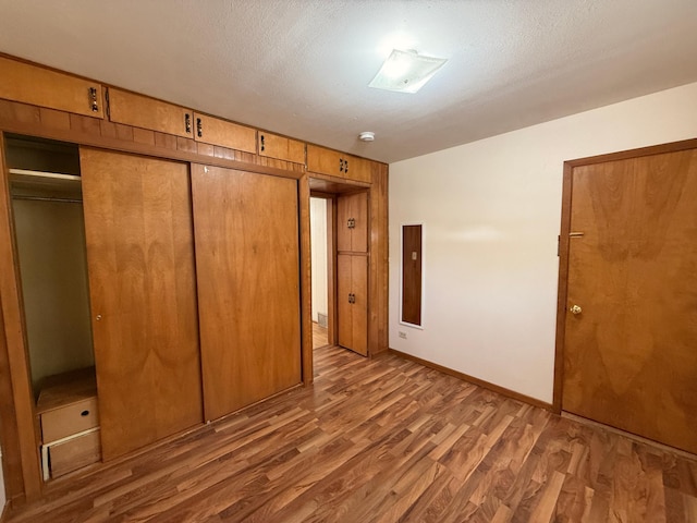 321 Western Ave, Madison, MN 56256 - unfurnished bedroom with wood finished floors, a closet, and baseboards