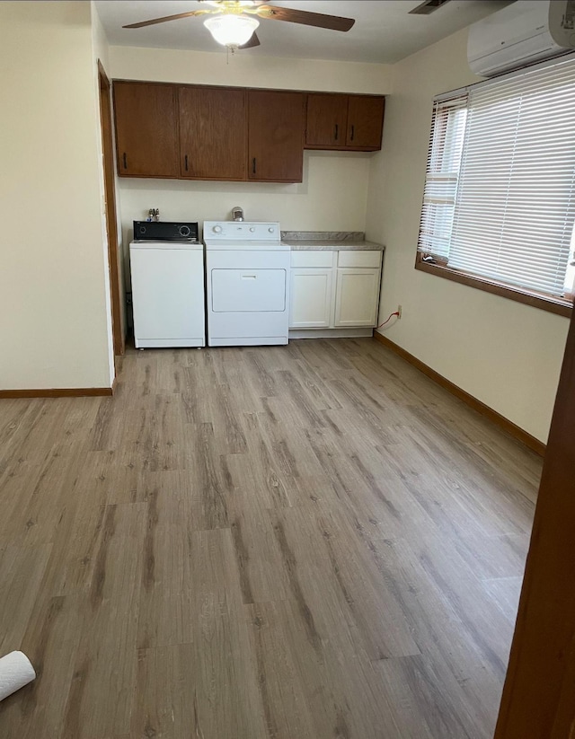 321 Western Ave, Madison, MN 56256 - clothes washing area featuring a wall unit AC, ceiling fan, cabinet space, light wood-style flooring, and baseboards