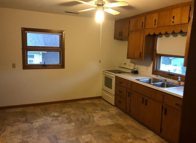 321 Western Ave, Madison, MN 56256 - kitchen with white electric range oven, a sink, baseboards, light countertops, and a ceiling fan