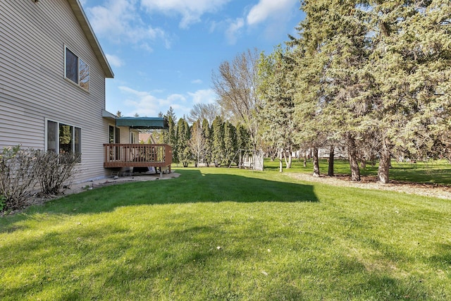 view of green lawn with a deck