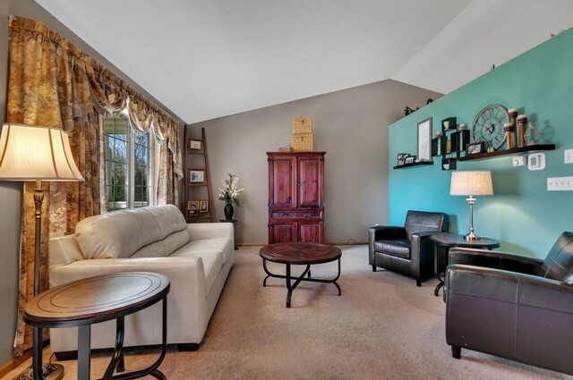 carpeted living area with vaulted ceiling and baseboards