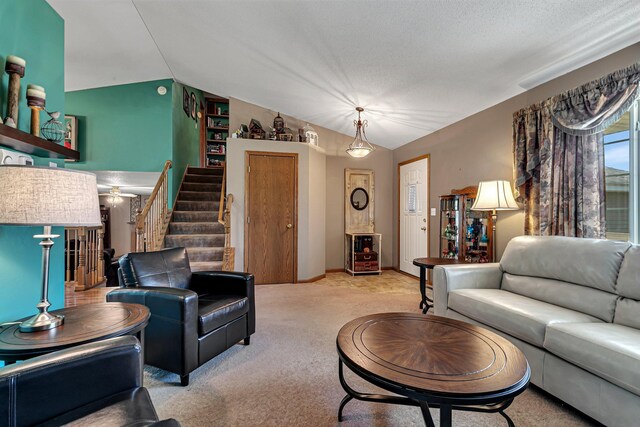 living room with lofted ceiling, carpet, and stairs