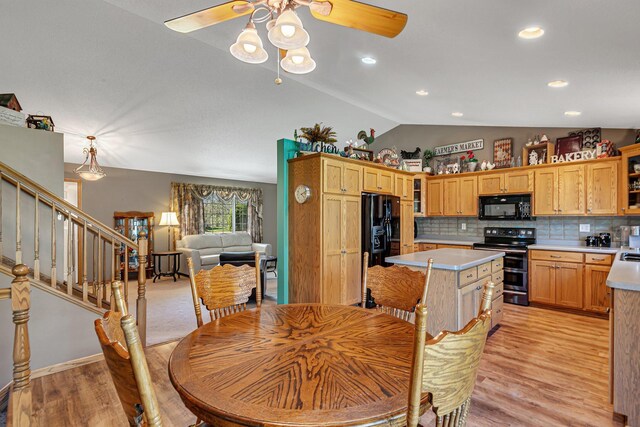 dining area with lofted ceiling, ceiling fan, light wood-style flooring, and stairway