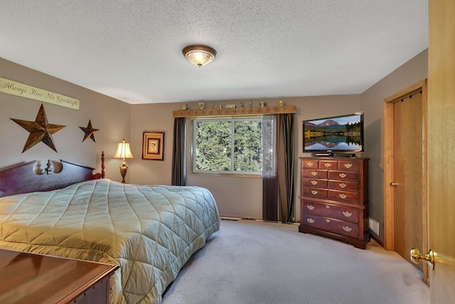 bedroom with light carpet and a textured ceiling
