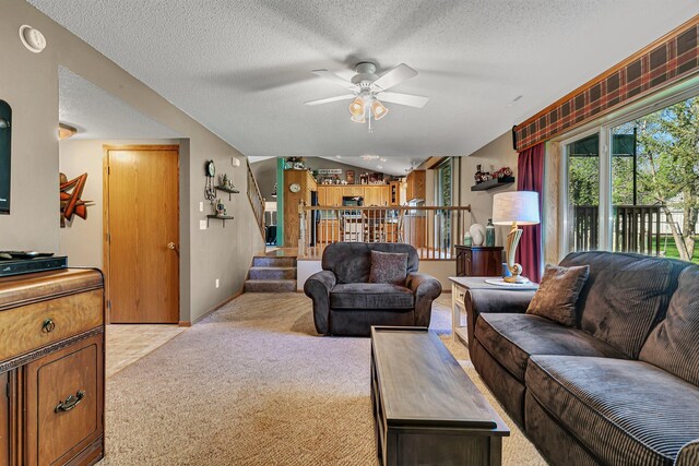 living area with light carpet, a ceiling fan, a textured ceiling, and lofted ceiling