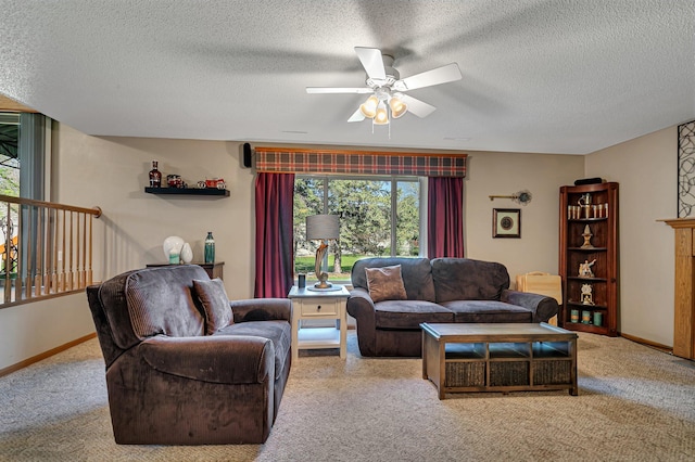 living area featuring carpet floors, a ceiling fan, a textured ceiling, and baseboards