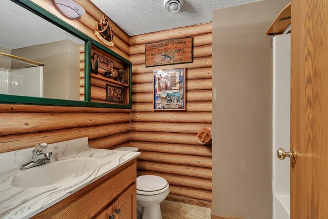 bathroom with a shower, a textured ceiling, toilet, vanity, and rustic walls