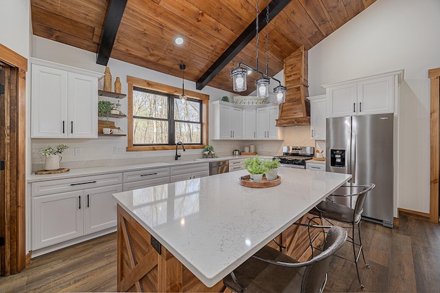 kitchen with appliances with stainless steel finishes, wooden ceiling, a sink, dark wood-style flooring, and a breakfast bar area
