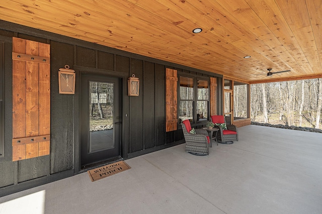 view of exterior entry with board and batten siding and covered porch
