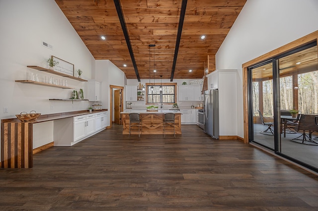 kitchen with freestanding refrigerator, wood ceiling, open shelves, high vaulted ceiling, and a kitchen breakfast bar