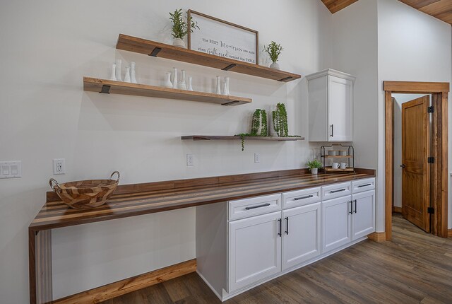 kitchen featuring open shelves, dark wood-type flooring, white cabinetry, wood counters, and a high ceiling