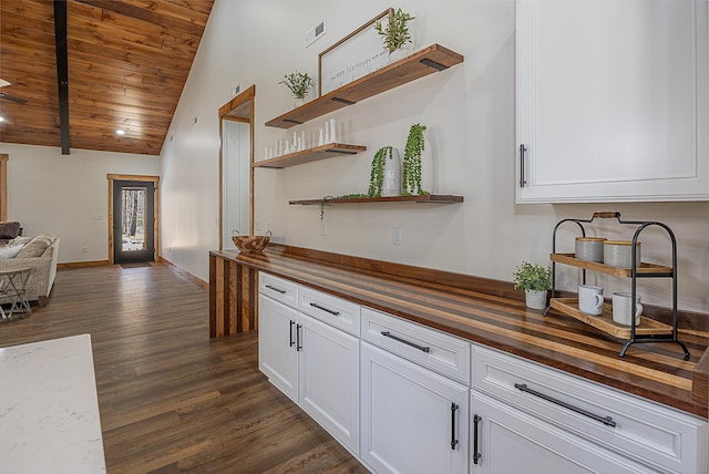 kitchen featuring butcher block countertops, dark wood-type flooring, wood ceiling, open floor plan, and white cabinets