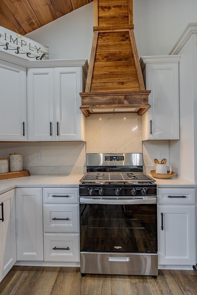 kitchen featuring stainless steel range with gas cooktop, custom range hood, wood finished floors, and light countertops
