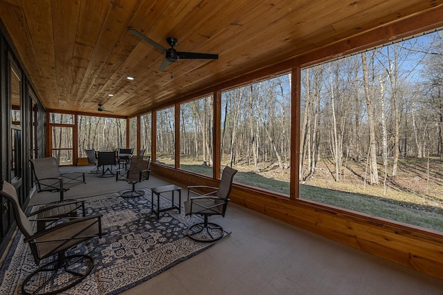 sunroom featuring a ceiling fan, wood ceiling, carpet flooring, and plenty of natural light