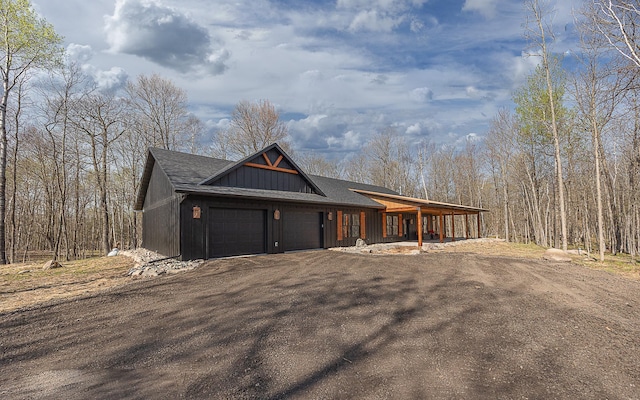 view of front of house with an attached garage, a porch, and driveway