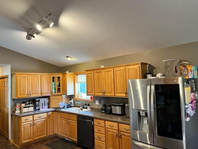 kitchen with a sink, black dishwasher, glass insert cabinets, stainless steel fridge with ice dispenser, and dark countertops