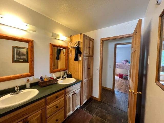 bathroom with double vanity, tile patterned flooring, baseboards, and a sink