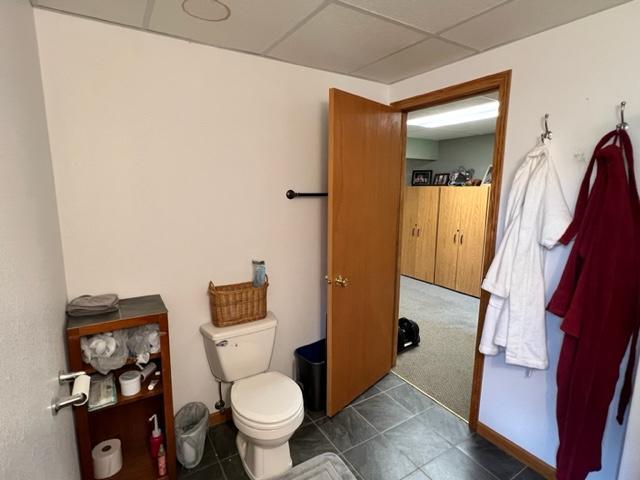 half bath with toilet and a drop ceiling