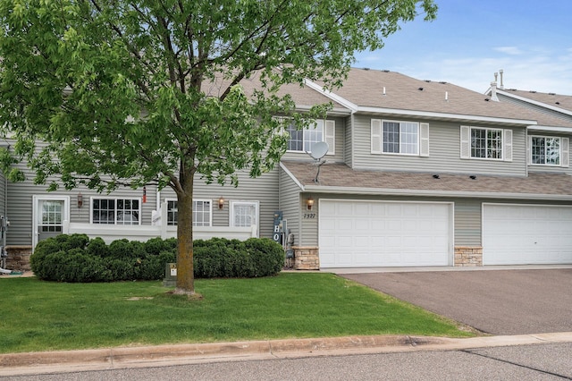 7327 Kalland Cir NE Unit 28, Otsego, MN 55301 - townhome / multi-family property with stone siding, asphalt driveway, a front yard, and an attached garage