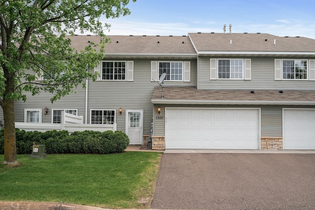7327 Kalland Cir NE Unit 28, Otsego, MN 55301 - townhome / multi-family property with stone siding, a front yard, asphalt driveway, and roof with shingles