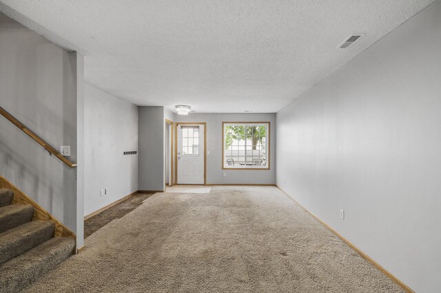 7327 Kalland Cir NE Unit 28, Otsego, MN 55301 - unfurnished living room with carpet, a textured ceiling, stairway, and baseboards
