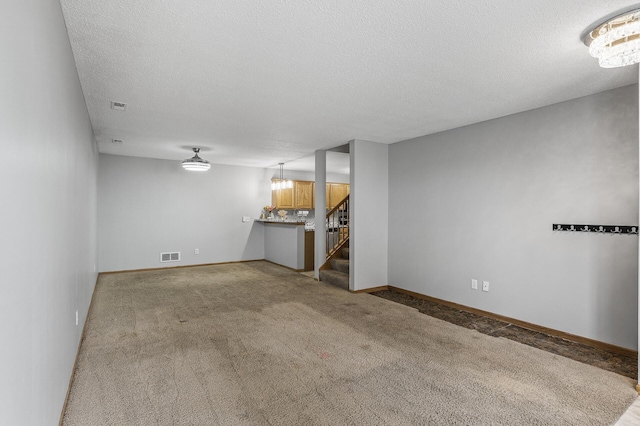 7327 Kalland Cir NE Unit 28, Otsego, MN 55301 - unfurnished living room featuring stairway, light carpet, a textured ceiling, baseboards, and a chandelier