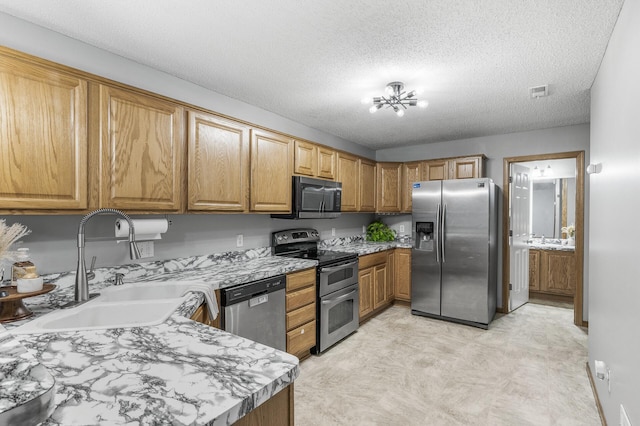 7327 Kalland Cir NE Unit 28, Otsego, MN 55301 - kitchen featuring stainless steel appliances, a sink, light countertops, brown cabinetry, and a textured ceiling