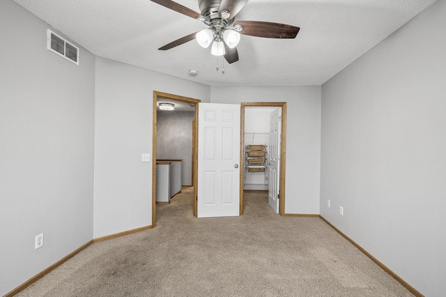 7327 Kalland Cir NE Unit 28, Otsego, MN 55301 - unfurnished bedroom with carpet, a textured ceiling, a spacious closet, baseboards, and ceiling fan
