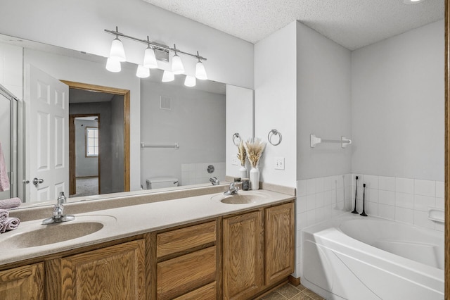 7327 Kalland Cir NE Unit 28, Otsego, MN 55301 - bathroom featuring toilet, a garden tub, double vanity, a textured ceiling, and tile patterned flooring
