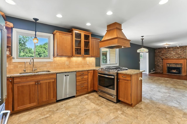5820 139th St W, Apple Valley, MN 55124 - kitchen with appliances with stainless steel finishes, island range hood, brown cabinets, open floor plan, and light stone counters